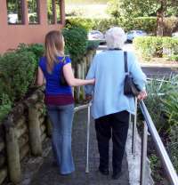 Woman helping older woman walk