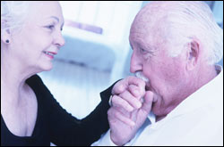 Older woman holding husband’s hand 