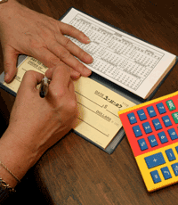 close up of a person filling out a large print check