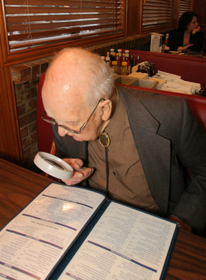 Older man reading with magnifier