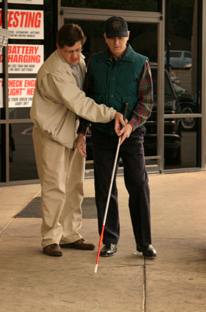  Photo d'un homme plus âgé apprenant à utiliser la canne de l'instructeur d'orientation et de mobilité 