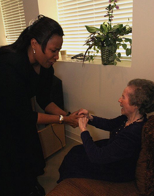 Picture of service provider holding hands with older woman