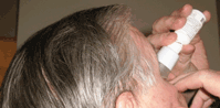 a man taking eye drops