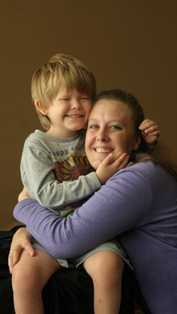 picture of visually impaired child and mother smiling and     hugging