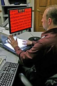 man using a video magnifier to read text