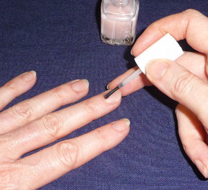 applying nail polish, using middle finger to stabilize brush just above the bristles