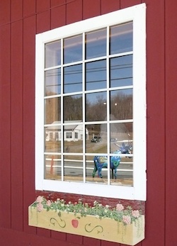 a window reflecting a large blue moose
