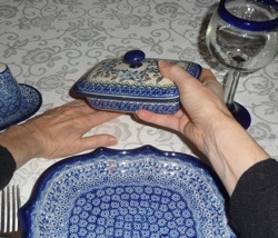 Moving butter dish with hand on bottom touching the tabletop and top of butterdish