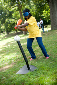 a girl at the 2012 family conference takes aim during teeball practice