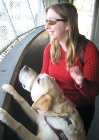 Alena with her guide dog Midge on the deck of a ferry boat