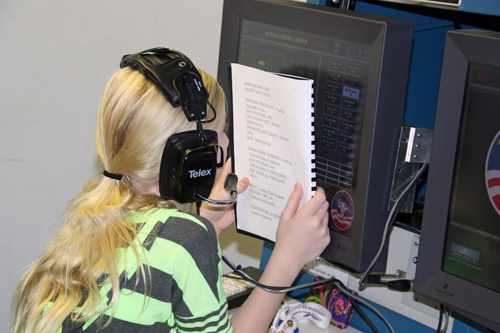 camper reads a large print manual during the space shuttle simulation