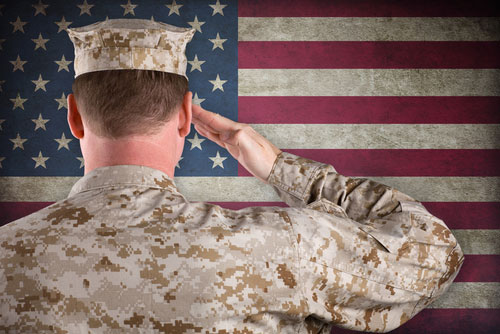 Soldier in Desert Fatigues Saluting an American Flag. 