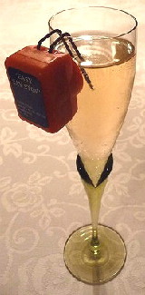 The prongs of an electronic liquid level indicator are placed over the rim of a tall champagne flute