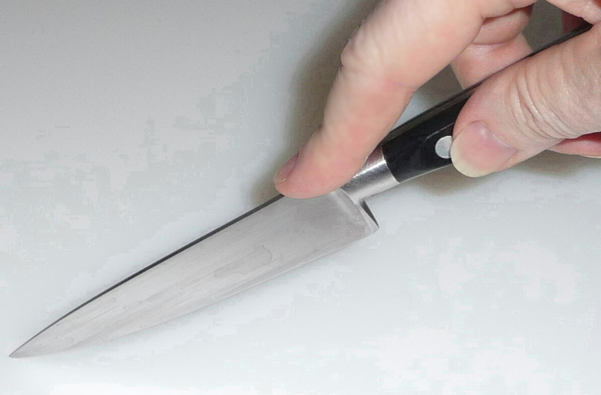A knife with the cutting edge facing downward
