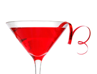 A Cosmopolitan cocktail served in a martini glass with a sprig of red ribbon