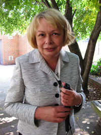 Lenore Dillon standing outside, white cane in hand