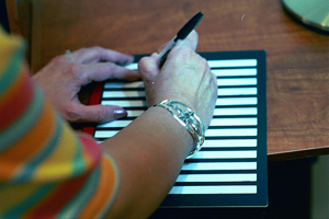 woman using a letter writing guide and dark black pen