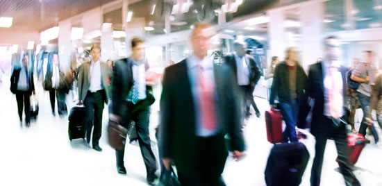 A group of travelers moving through an airport. Motion blur.
