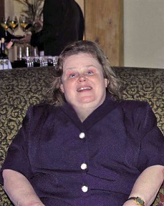 Sharon Fridley sitting in a chair, smiling.