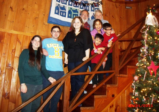 Susan Harper and family, posed on the staircase by a decorated Christmas tree