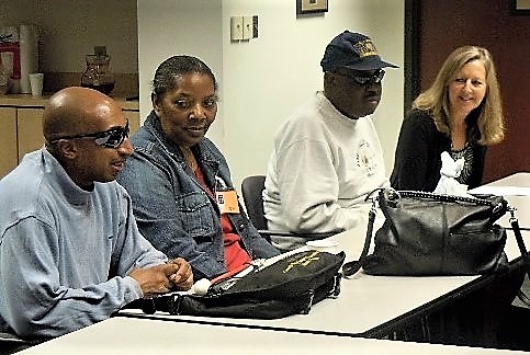 Four people sitting at a table during support group meeting