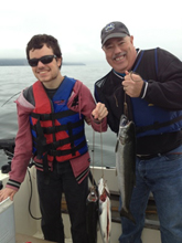 Bob and Mike, smiling and holding up the fish they caught