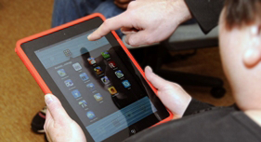 iPad with hand indicating apps on the screen