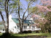 two story house with pink dogwood in bloom