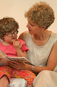 A mother reading with her visually impaired daughter