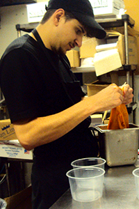 Brandon standing at a prep table in a restaurant kitchen