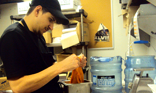 Brandon standing at a prep table in a restaurant kitchen