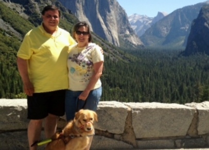 Audrey, dog guide, and husband standing in front of El Capitan Yosemite