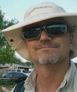 Stephen is sporting a wide brim hat, whit in color with dark sunglasses.