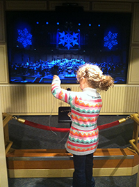 Madilyn at the Boston Children's Museum, conducting a virtual symphony!