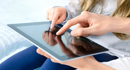 closeup of daughter and parent touching an iPad screen together