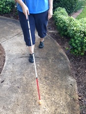 picture of person walking with long white cane extended
