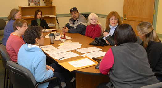 student, parents, teachers and administrators gathered around a table