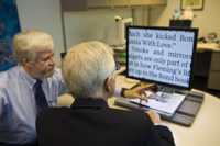 low vision therapist at the Maxwell Low Vision Clinic showing patient electronic magnifier