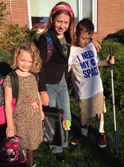 Emily Coleman's children standing together outside, prepared to head off to school