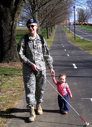 Tim Hornik, Veteran, walking with white cane holding daughter's hand