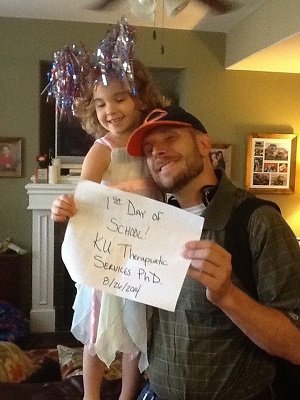 Tim holding daughter and announcement of first day of school
