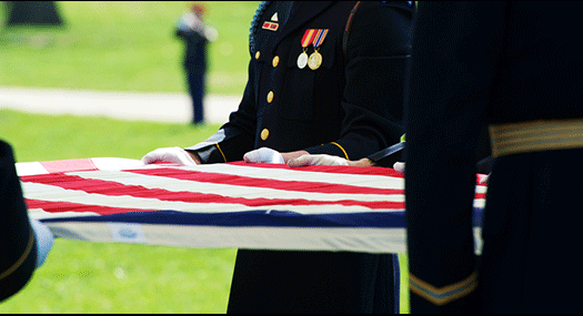 honor guard holding U.S. flag, with bugler in the background