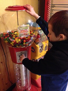 Eddie putting money in a giant gumball machine