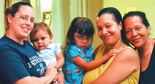 three women, two of whom are holding young children