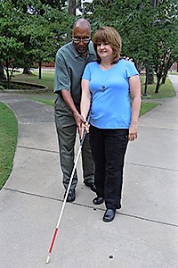 male orientation and mobility instructor shows a woman how to use her white cane