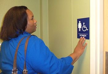 empish reading braille sign on bathroom