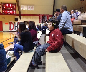 Eddie Sitting in Bleachers at Basketball Game