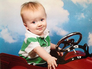 Eddie as baby sitting up in toy car