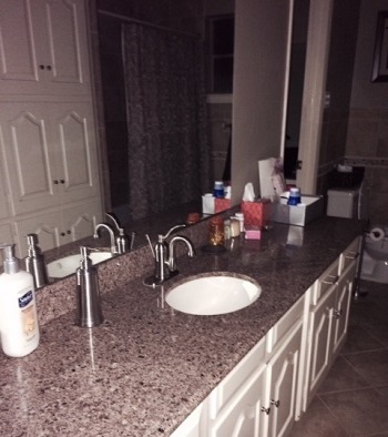 bathroom with makeup on counter and no light