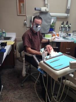 Sue smiling in dentist chair, dentist standing be side her